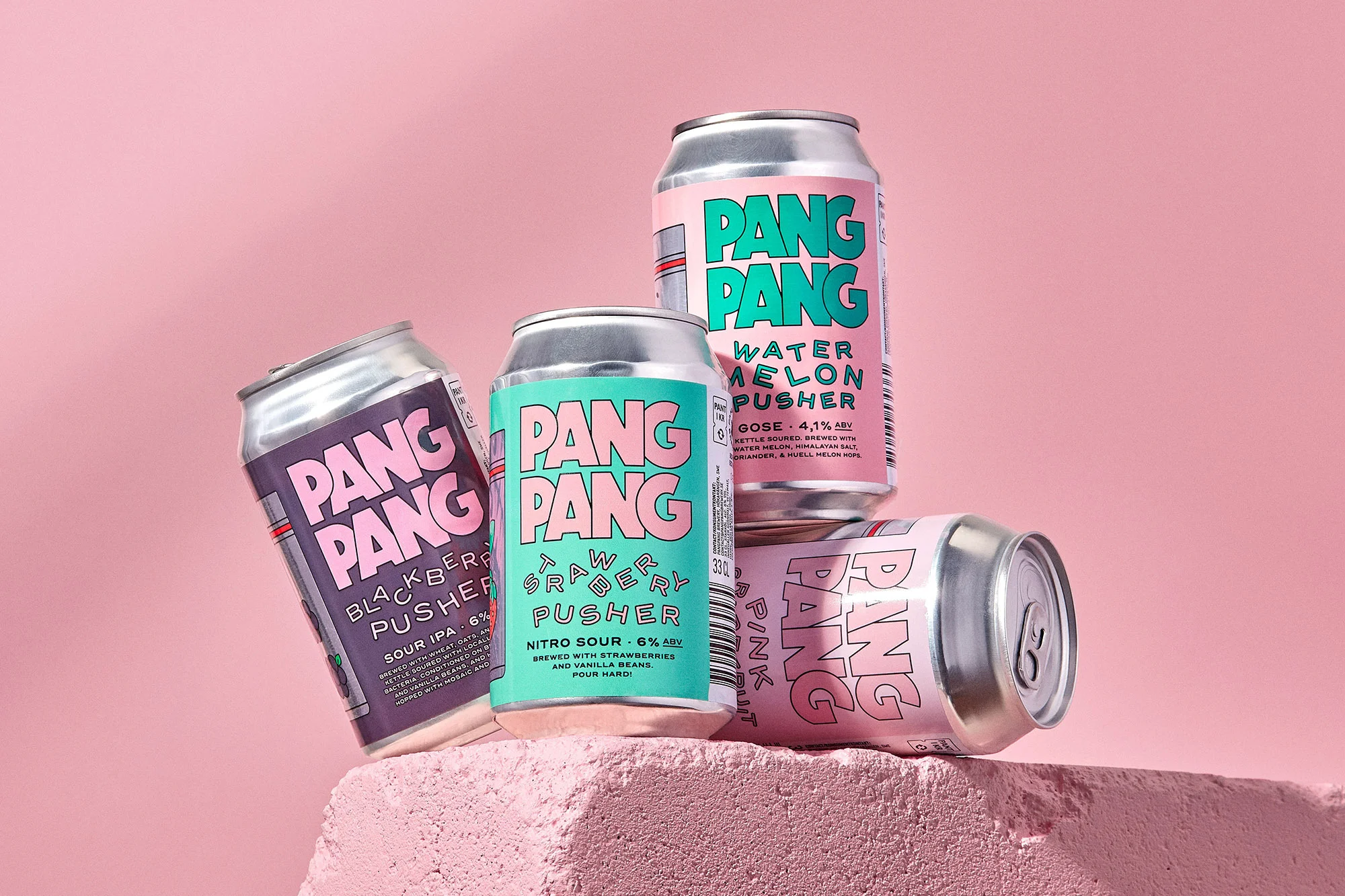 Four colorful Pang Pang craft beer cans stacked creatively on a pink textured surface, set against a solid light pink backdrop. Product shot.