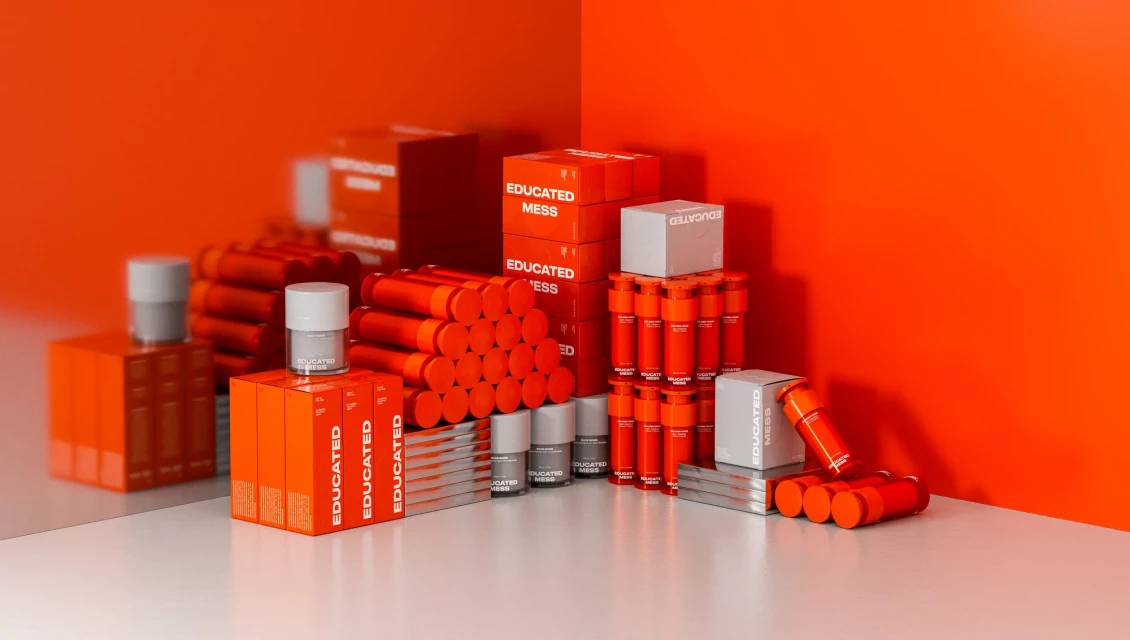Stacks of vibrant orange and white product boxes and bottles arranged against a coordinating orange background, creating a bold, cohesive product display.