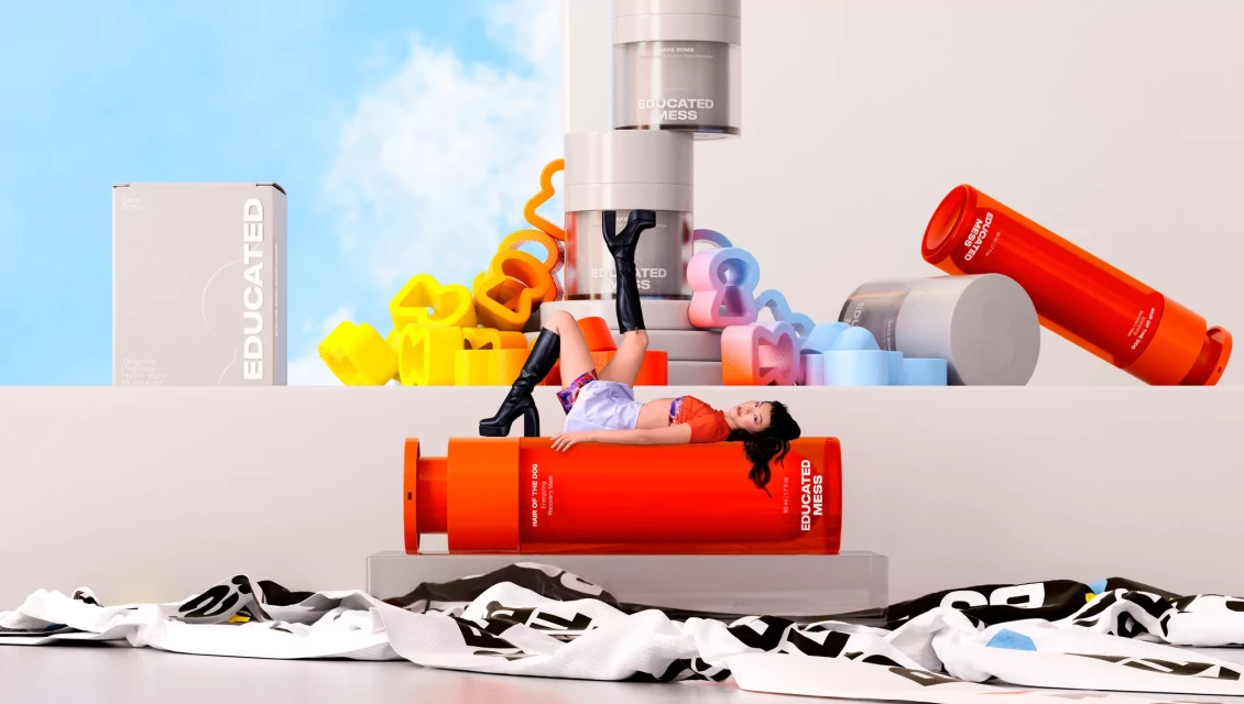 Woman lying on Educated Mess product with colorful shapes and beauty product containers in a studio against a blue sky backdrop.