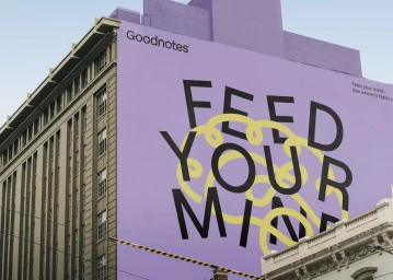 Goodnotes outdoor mural featuring bold typography reading Feed Your Mind against a large purple building facade.