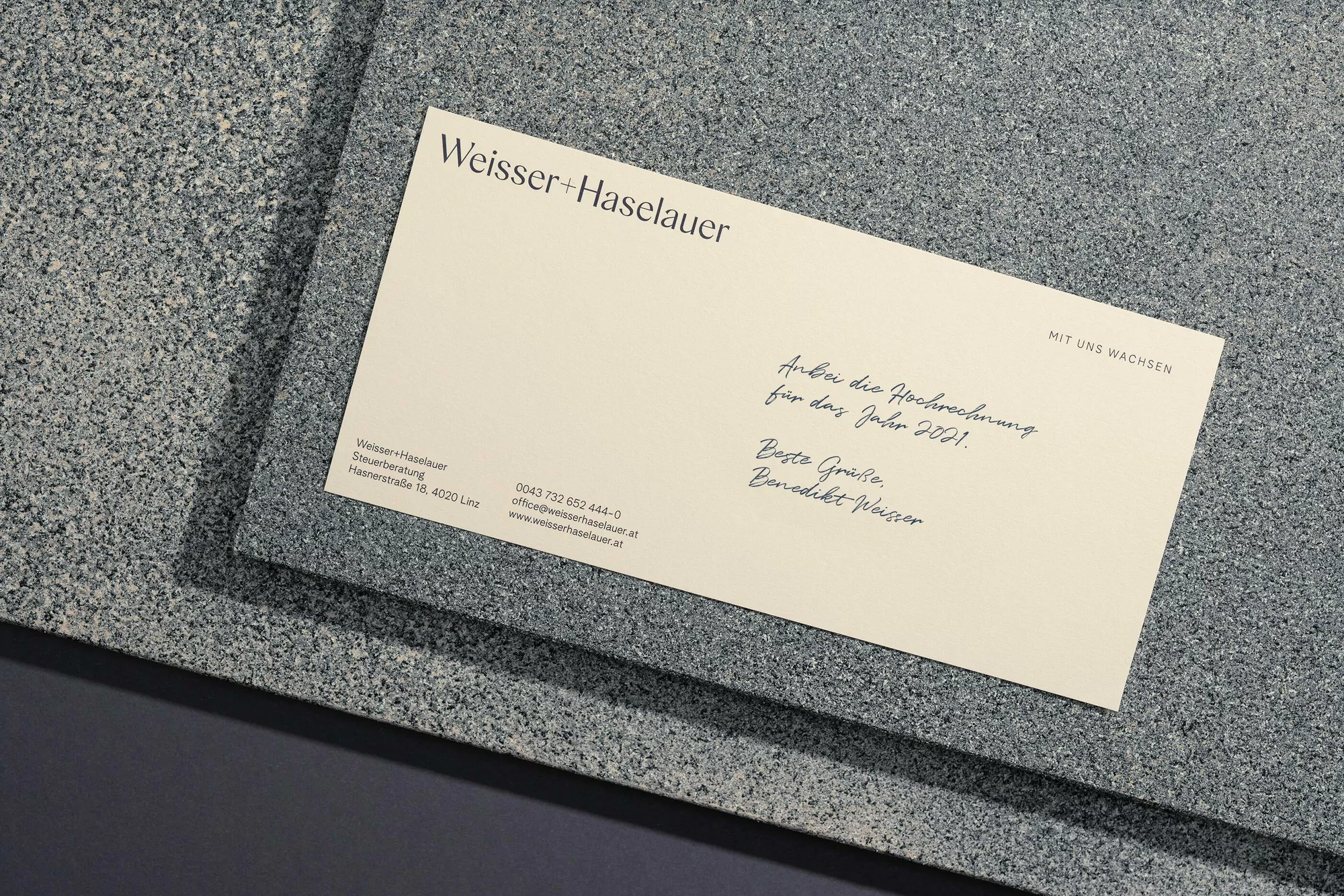 Business card featuring Weisser+Haselauer logo with financial text against a textured gray background, emphasizing corporate communication.