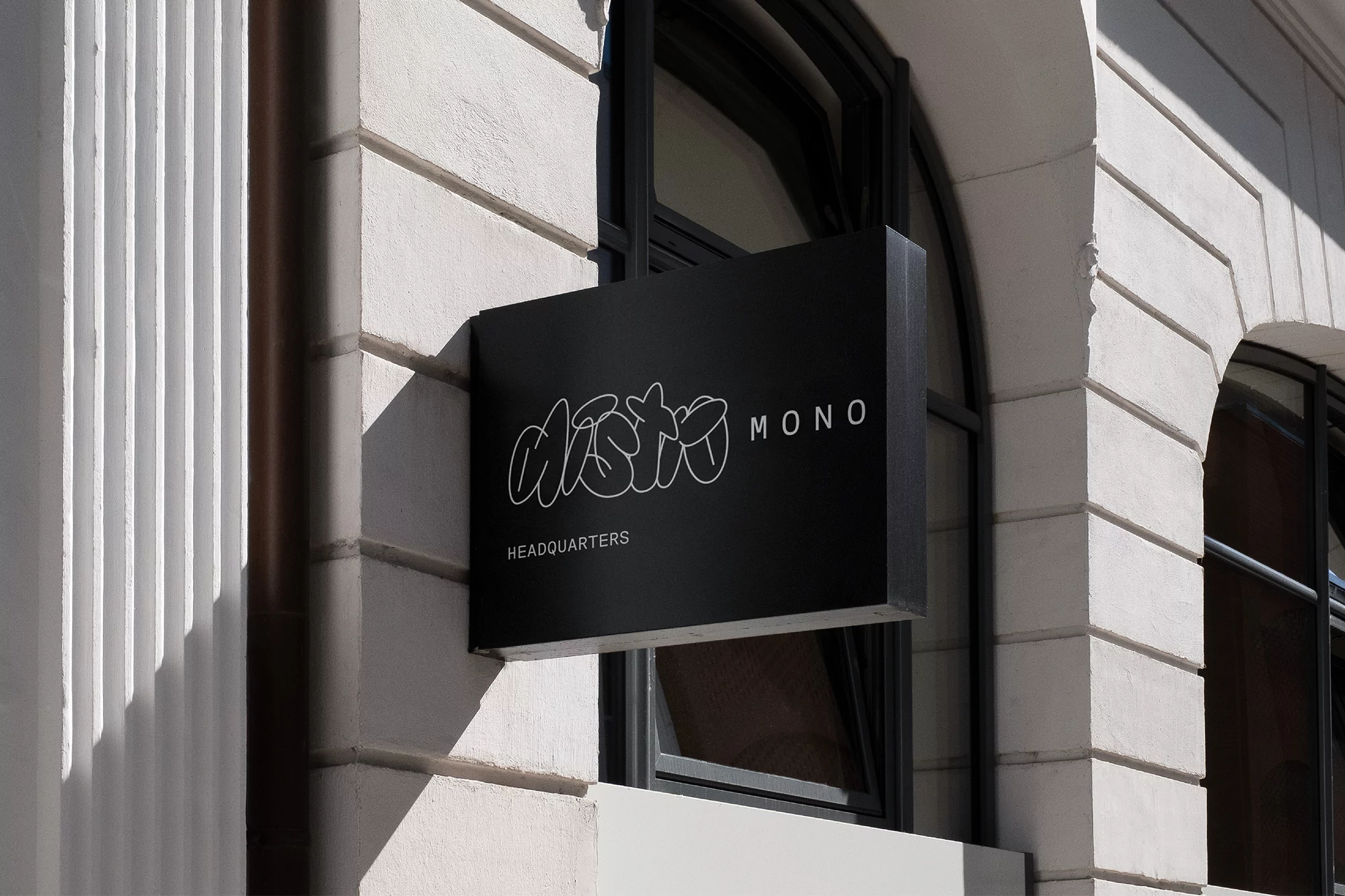 Exterior building shot featuring a black business sign reading 'Aisto Mono Headquarters', showcasing modern architecture.