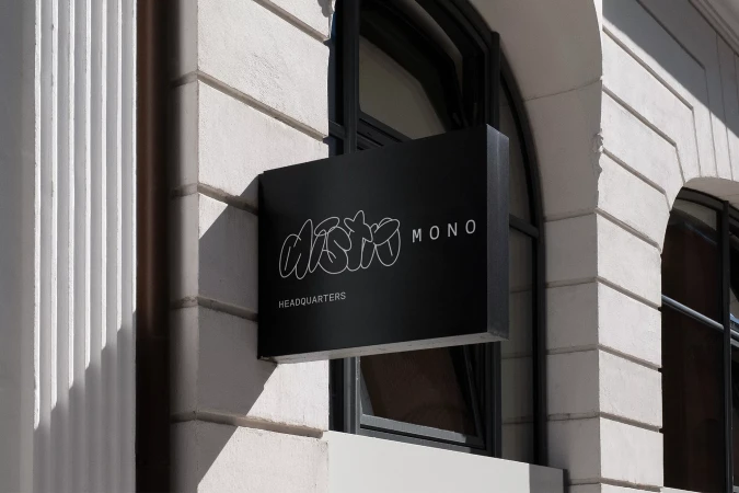 Exterior building shot featuring a black business sign reading 'Aisto Mono Headquarters', showcasing modern architecture.