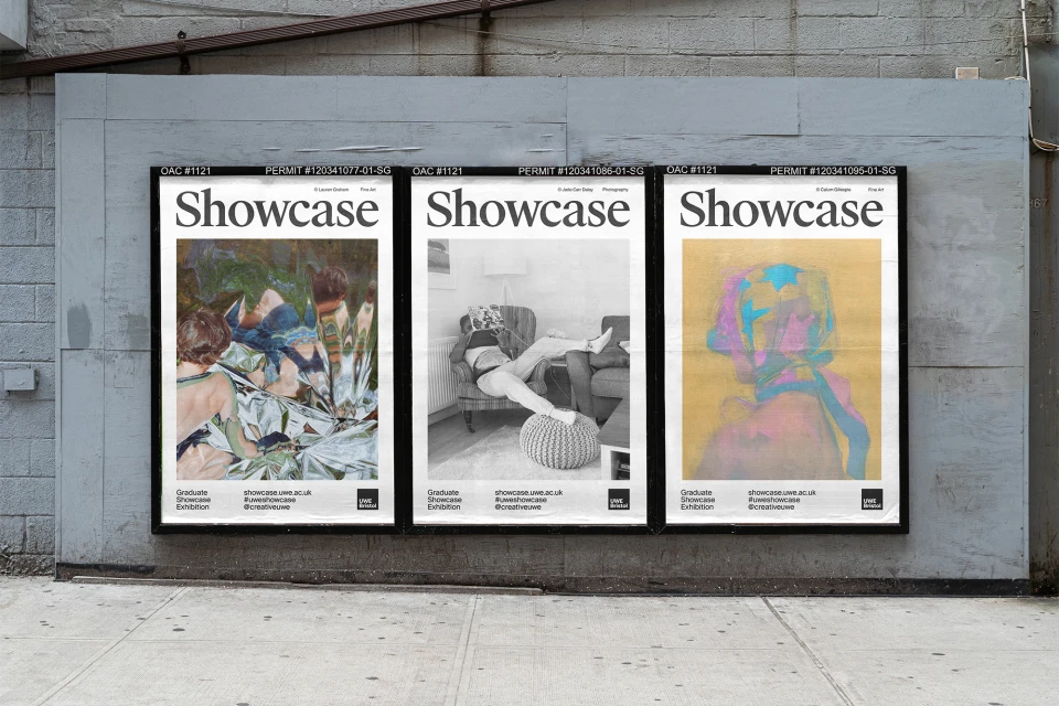 Three 'Showcase' posters displayed on a concrete wall alongside a sidewalk, advertising a graduate exhibition with diverse art pieces.