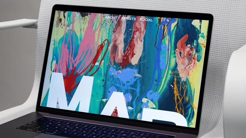Laptop displays a vibrant digital painting on its screen, showcasing a colorful artistic interface with prominent text overlay.