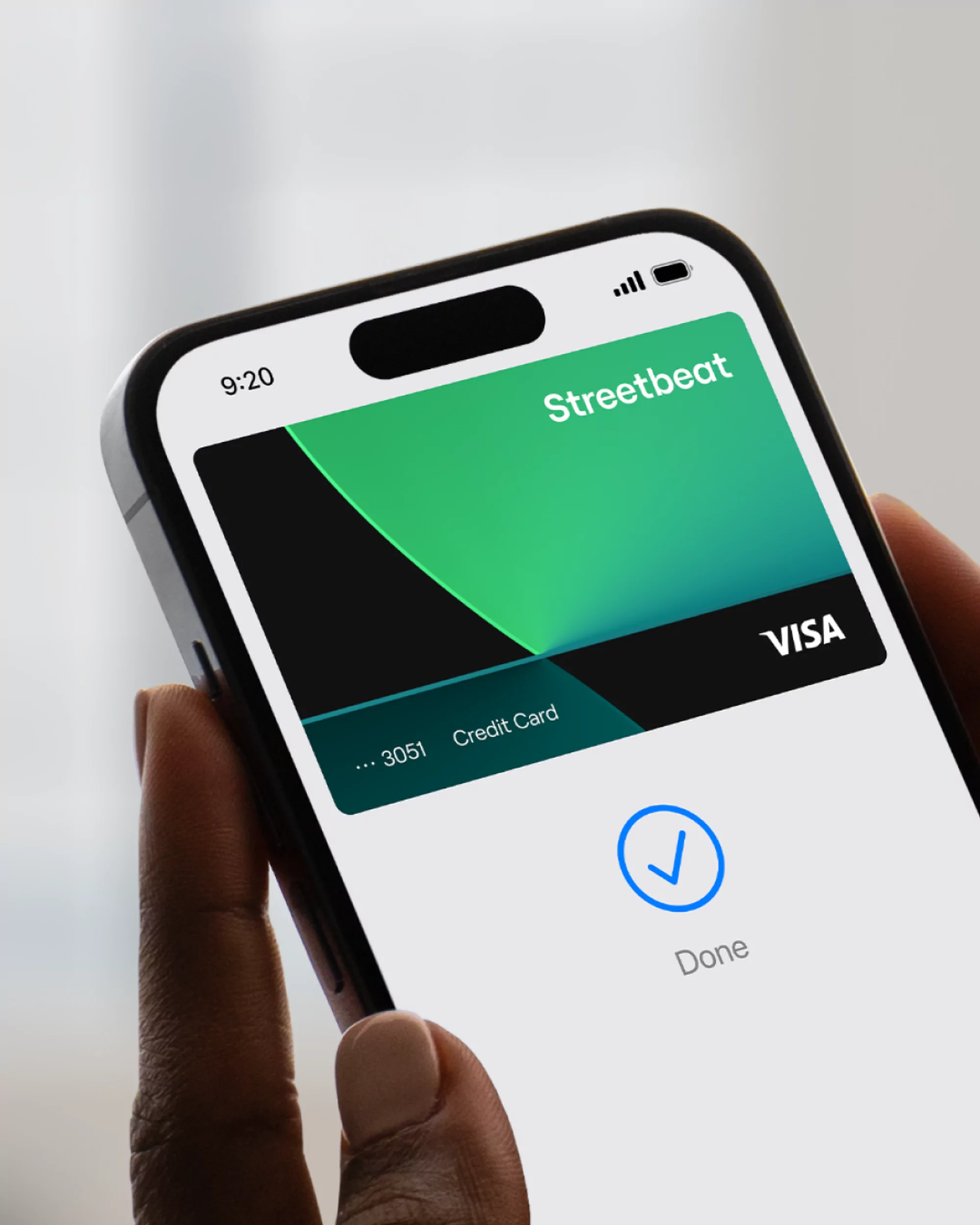 Digital payment confirmation on smartphone. Finger touching phone screen showing a mobile payment completed with the Streetbeat card.