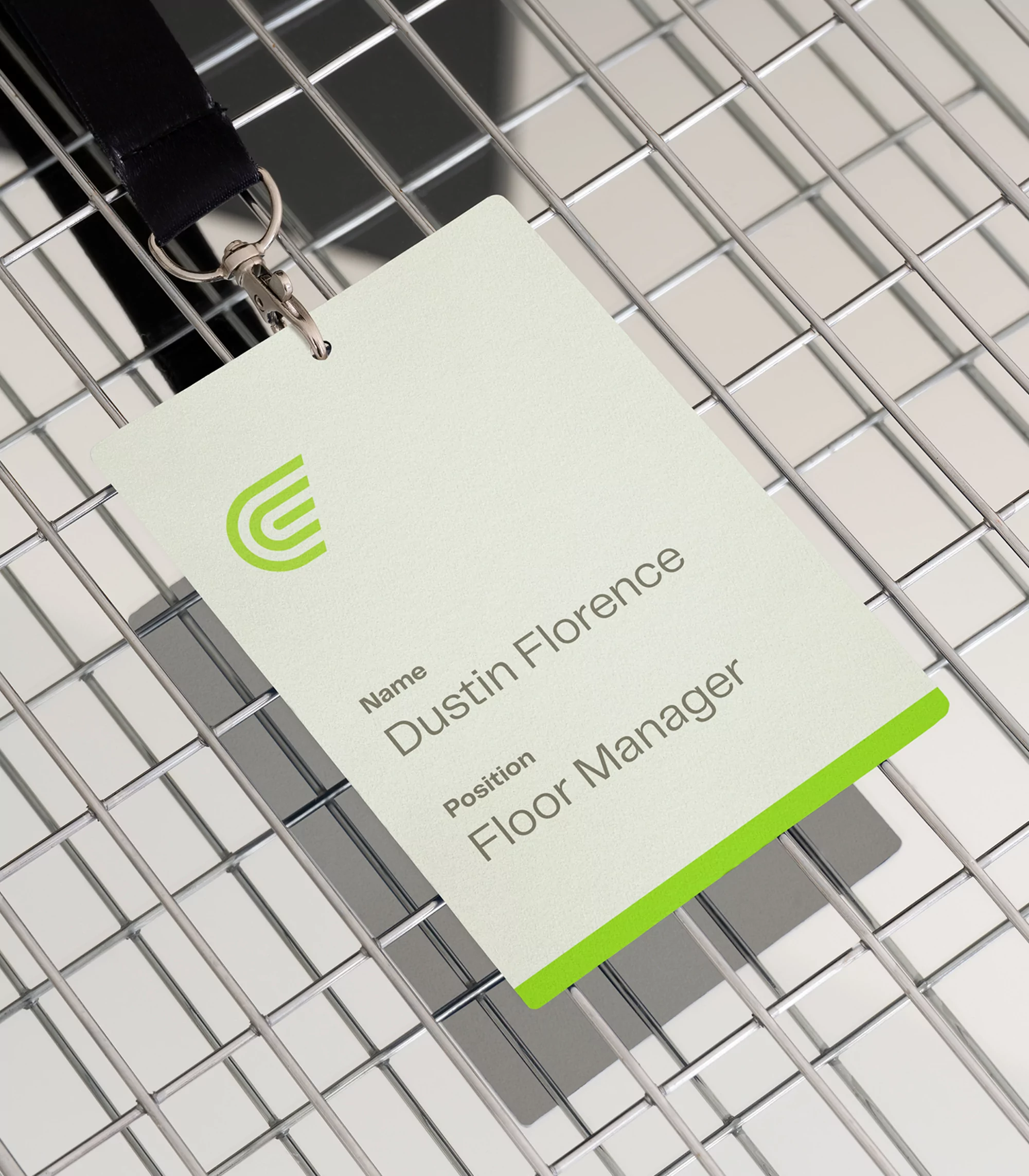 ID badge on a metal grid, features a modern logo, the name 'Dustin Florence' and 'Floor Manager' title, with a black lanyard.