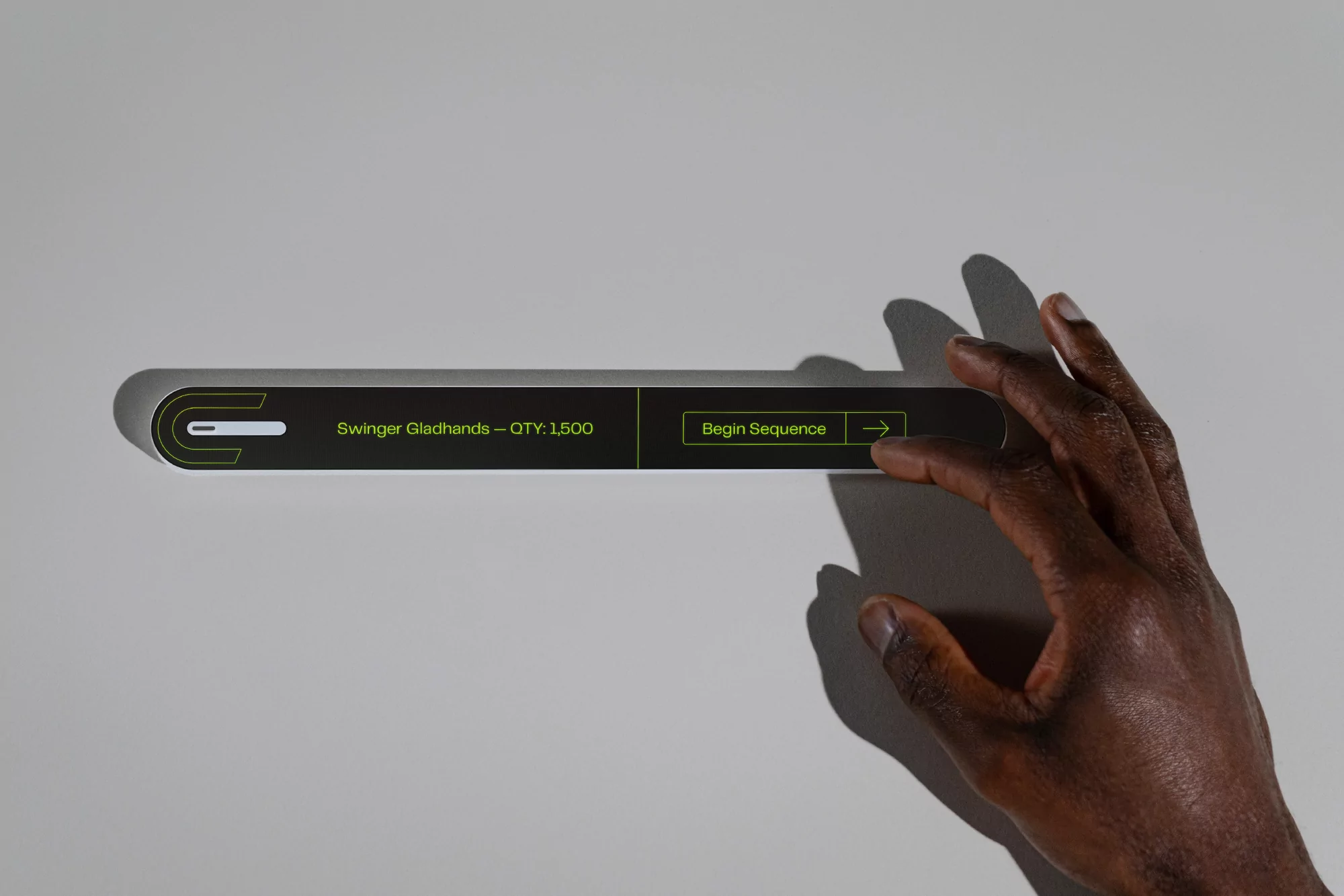 Close-up of a dark-skinned hand interacting with a sleek, futuristic control panel featuring text and a graphical user interface element.