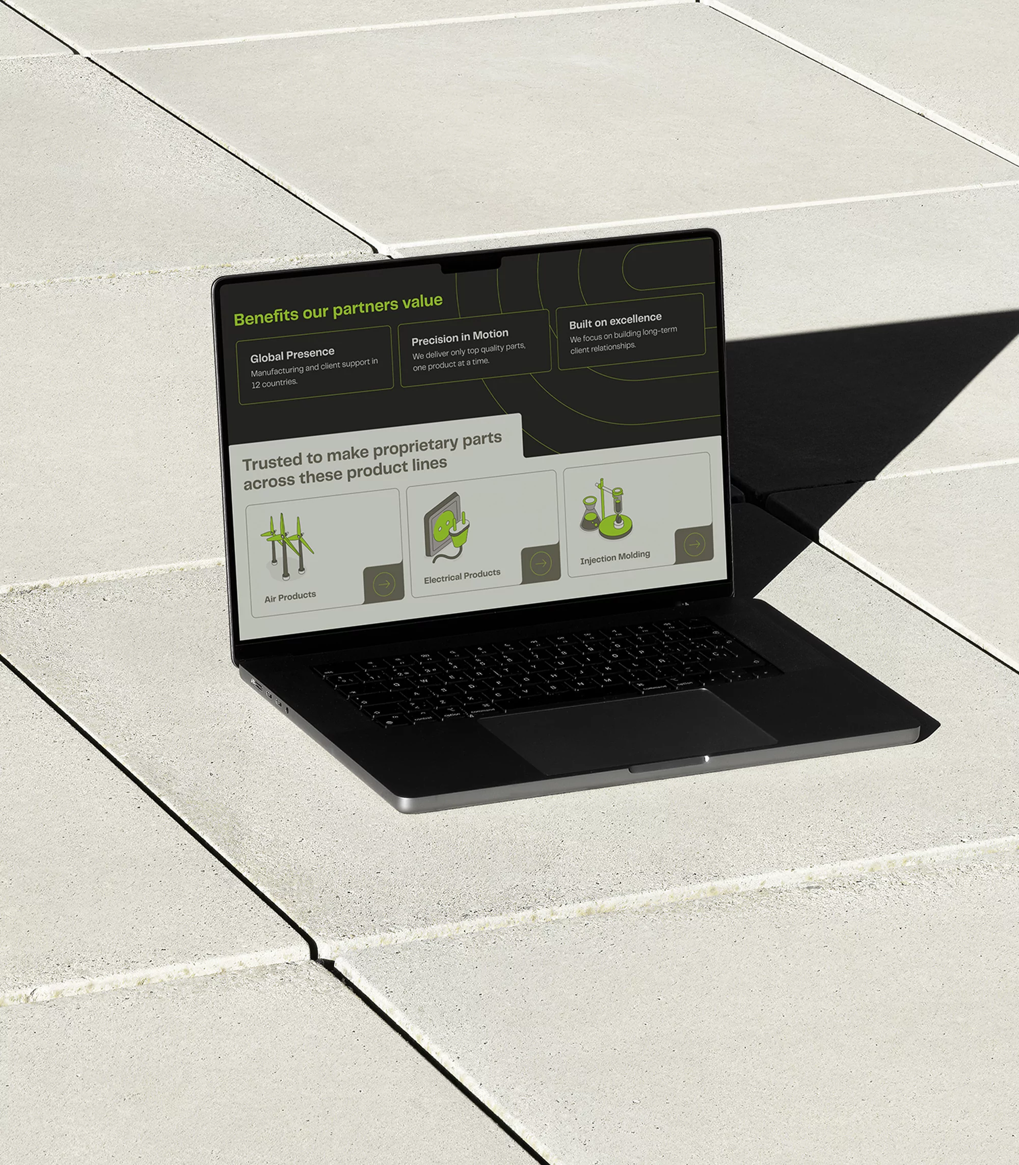 Laptop on concrete surface displays website with graphics and text promoting products and services. Modern design. Focus on business.