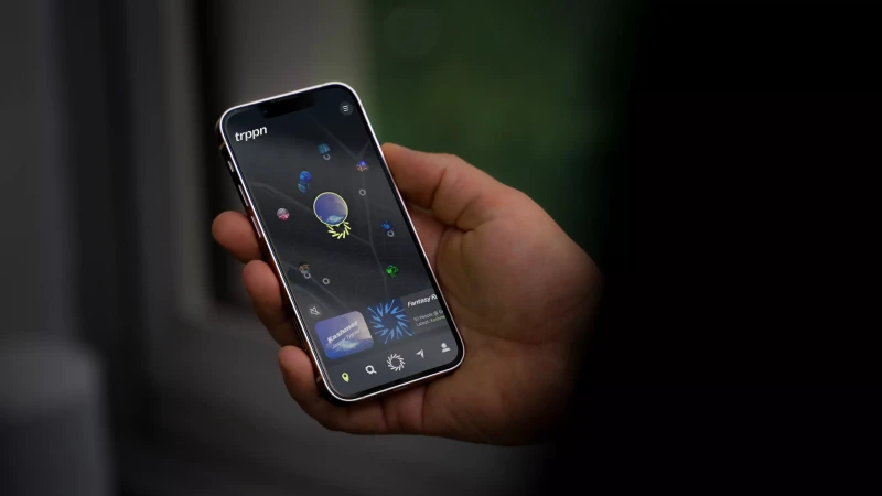 Close-up of a hand holding a smartphone displaying a colorful app interface with abstract graphics and menu icons.