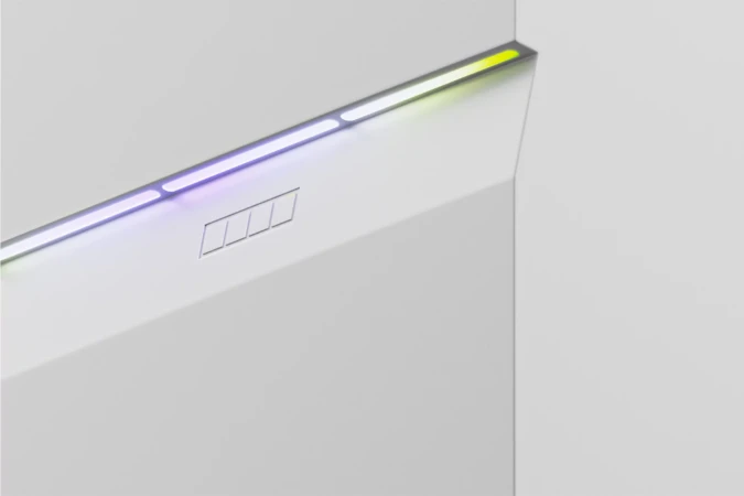 Abstract close-up of a minimalist white structure with linear multicolored LED lighting highlighting its angular geometric forms.