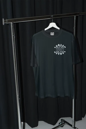Black t-shirt with white graphic design hanging on a white hanger displayed on a metal clothing rack against a black background.