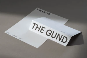 Branded stationery set featuring the name The Gund on white paper against a neutral grey surface.
