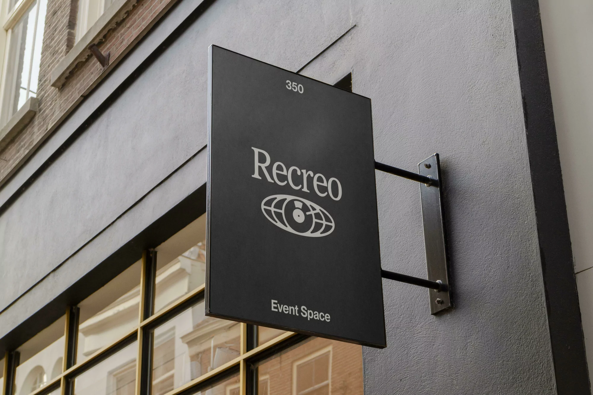 Sign for 'Recreo Event Space' outside a building with a dark background and a logo featuring a stylized globe-like design.