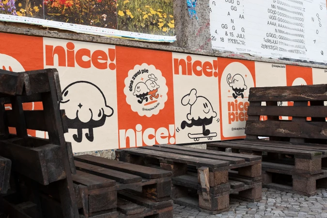 Urban scene displays wood pallet furniture next to a colorful mural featuring cartoon ice cream characters and the text "nice!" in bright colors.