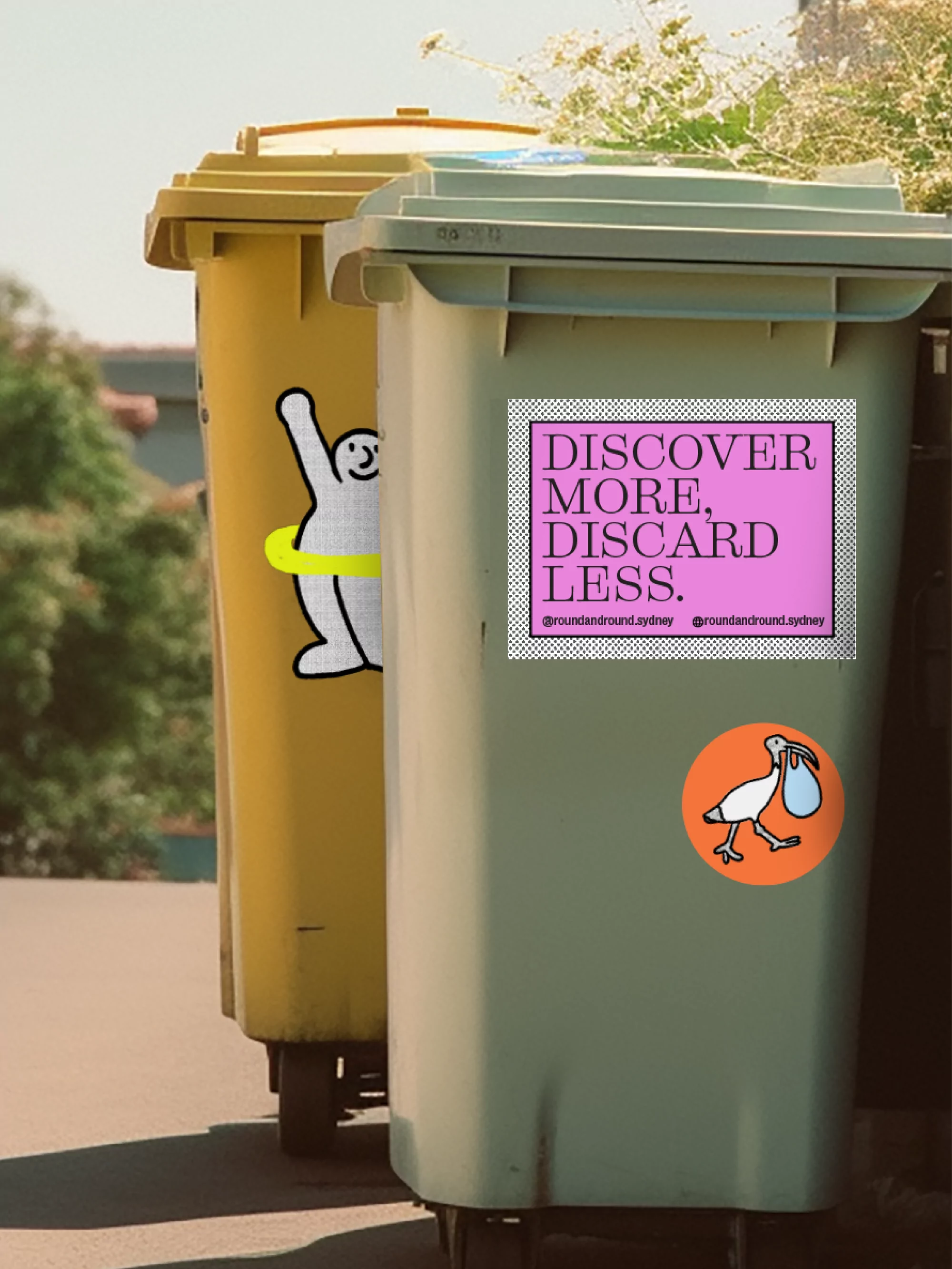 Two wheelie bins, one yellow and one green, adorned with graphic stickers, stand outdoors with greenery visible behind them.