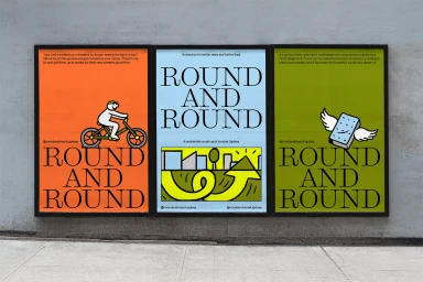 Three framed posters for Round and Round mounted on a weathered concrete wall above a sidewalk.