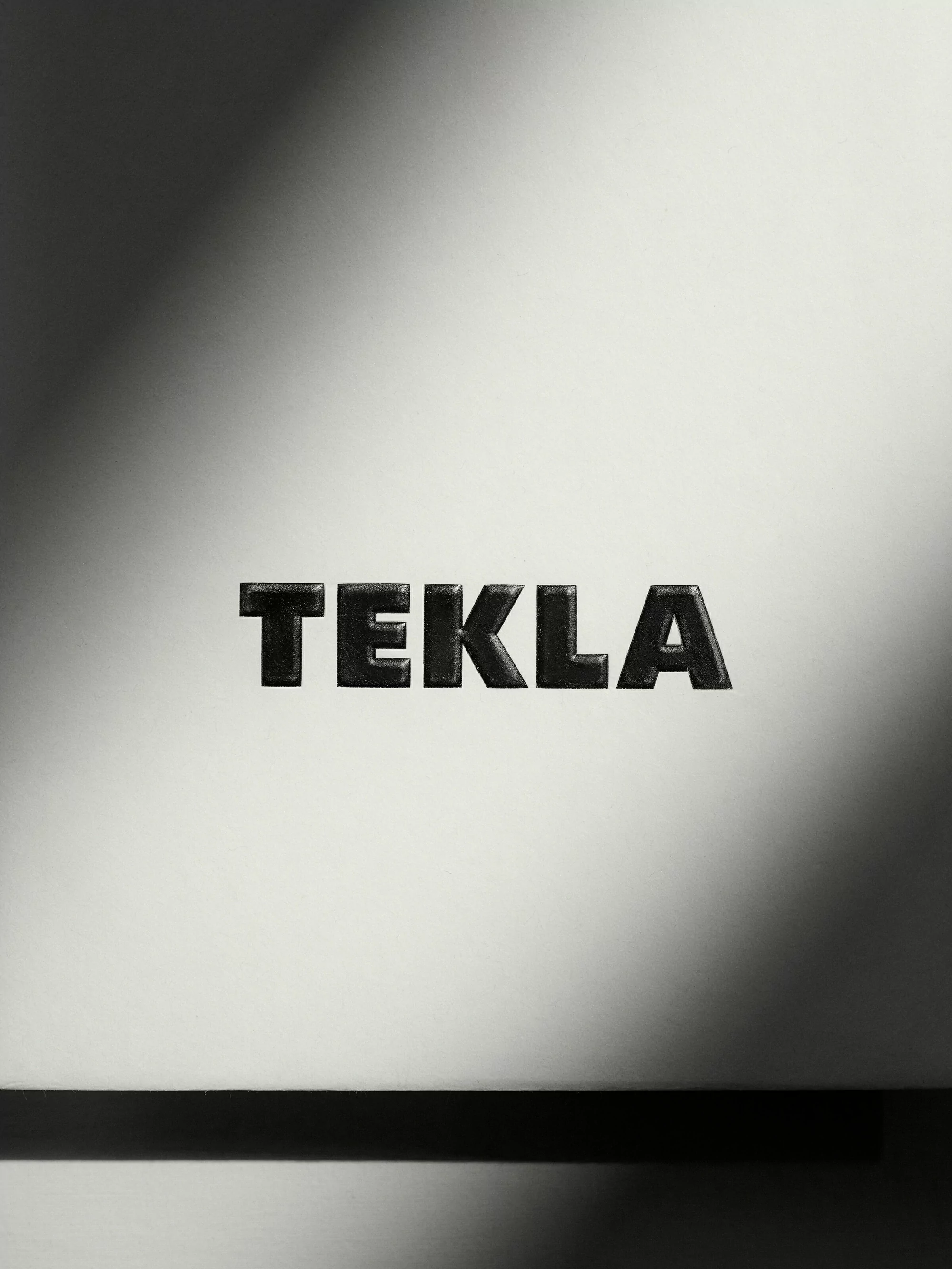 Textured 'TEKLA' typography against a gradient background with a dark horizontal line at the bottom suggests a minimalist, modern aesthetic.