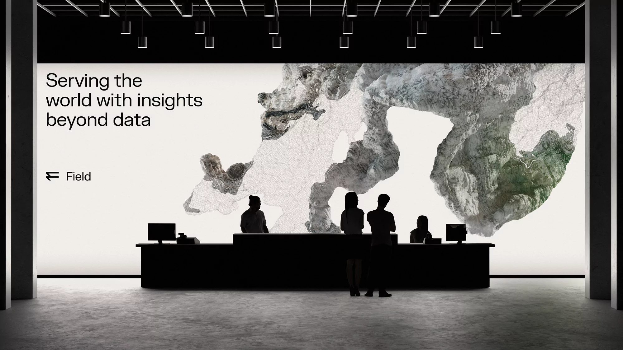People at a dark reception desk with computer monitors, silhouetted against a backdrop featuring abstract cloud-like art and text.