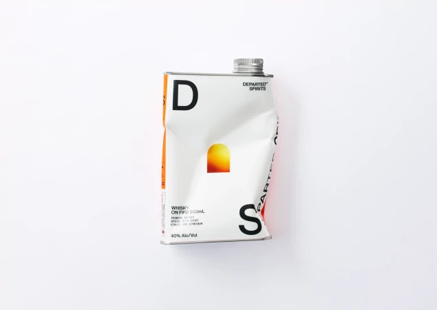 A dented white metal flask with typographic branding resting on a plain white background.