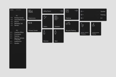 Black minimalist wayfinding signage system with white text and directional icons against a light grey background.