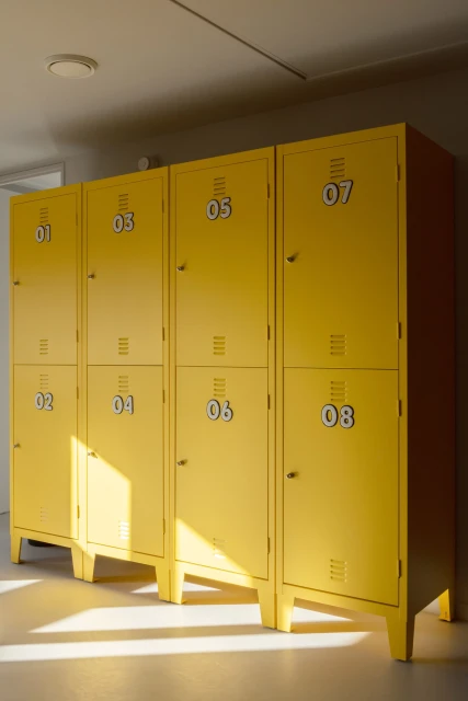 Bright yellow metal lockers with numbered doors, arranged in a row in a clean, well-lit indoor setting, creating a playful and functional storage solution.