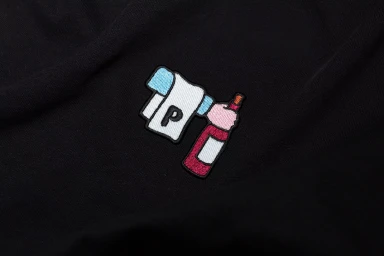 Embroidered patch featuring a bottle and towel graphic on a black fabric background