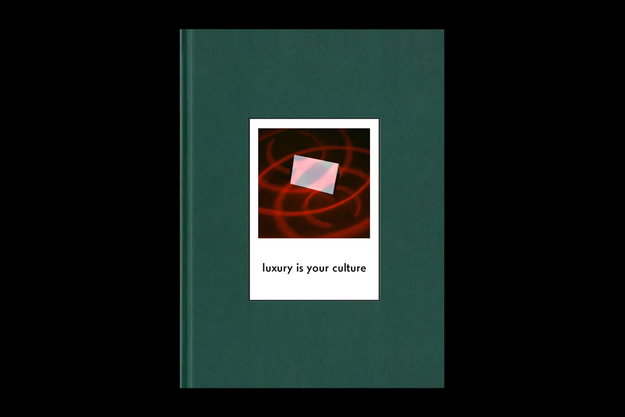 Close-up of a dark green hardcover book featuring a square photograph with the text "luxury is your culture" centered below.