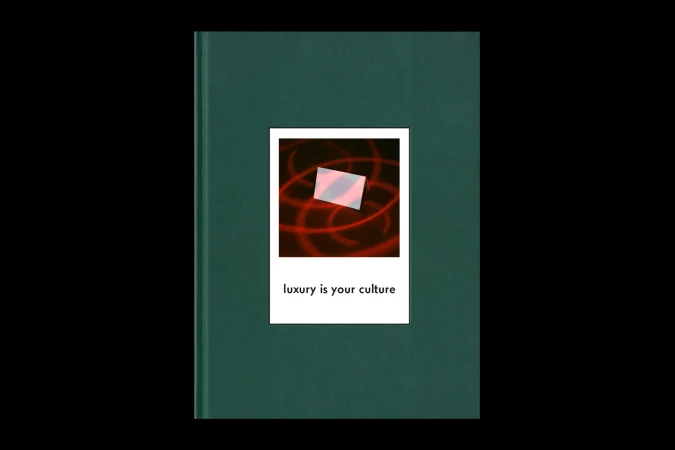 Close-up of a dark green hardcover book featuring a square photograph with the text "luxury is your culture" centered below.