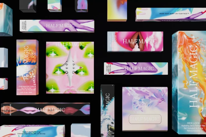 Cosmetic products including eyeshadow palettes, eye liners, and lipsticks from Half Magic against a black background in a studio product shot.