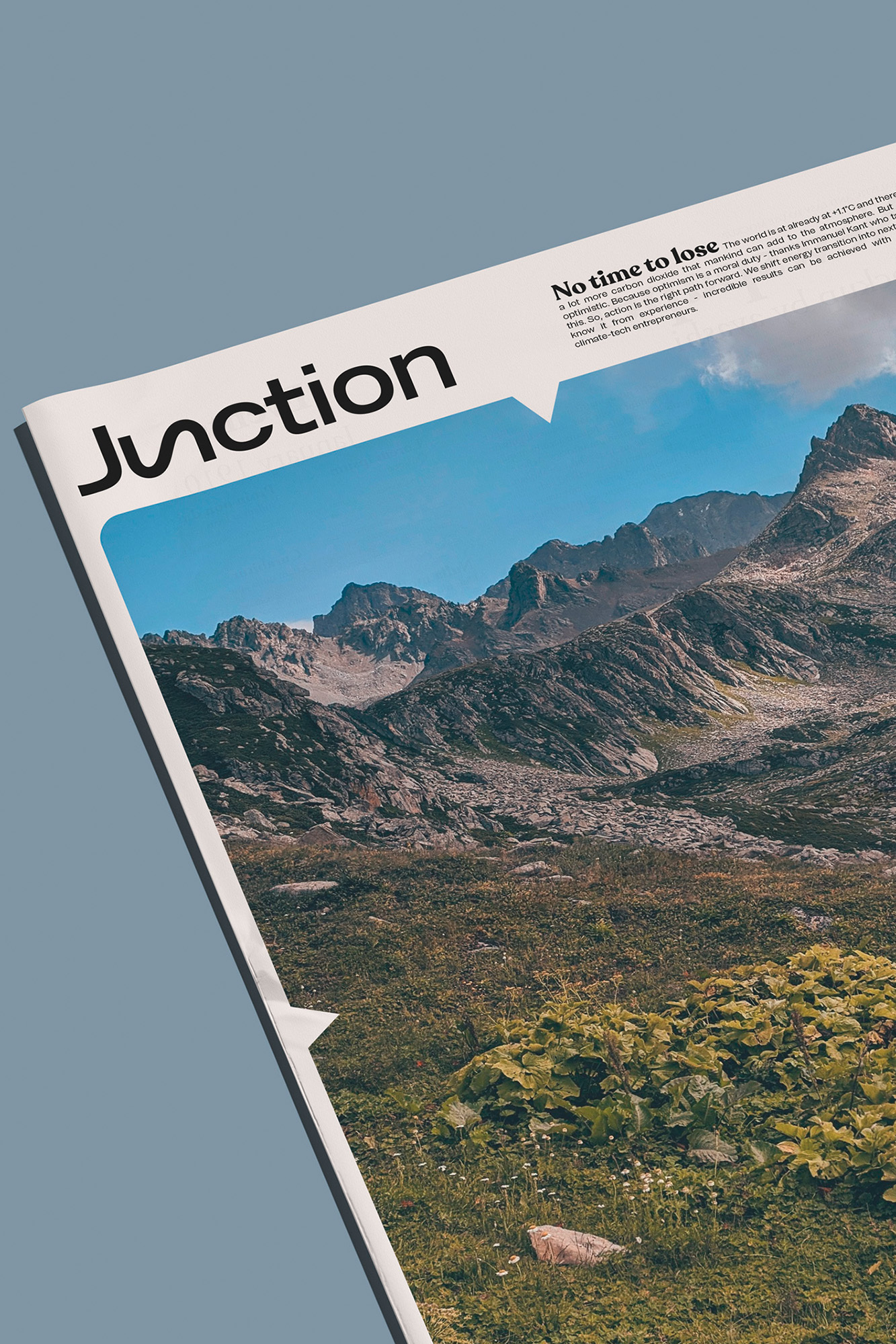 Close-up of a printed publication mockup featuring the Junction brand name and a mountainous landscape photograph.