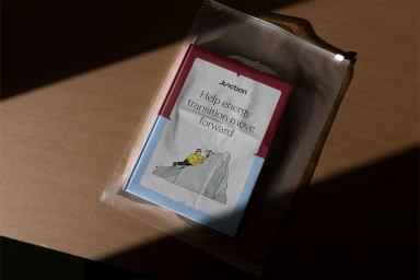 Book with illustrated cover in a clear plastic zipper bag resting on a brown paper surface under hard diagonal sunlight