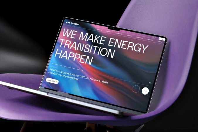 Laptop displaying Maire website with focus on renewable energy transition on a violet chair against a dark backdrop, tech and innovation.