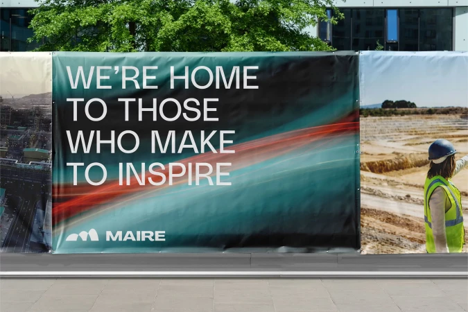 Outdoor banner ad for Maire company featuring the company logo and worker in hard hat, photographed during daytime.