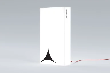 White rectangular light box product with a curved black logo symbol against a seamless light grey background