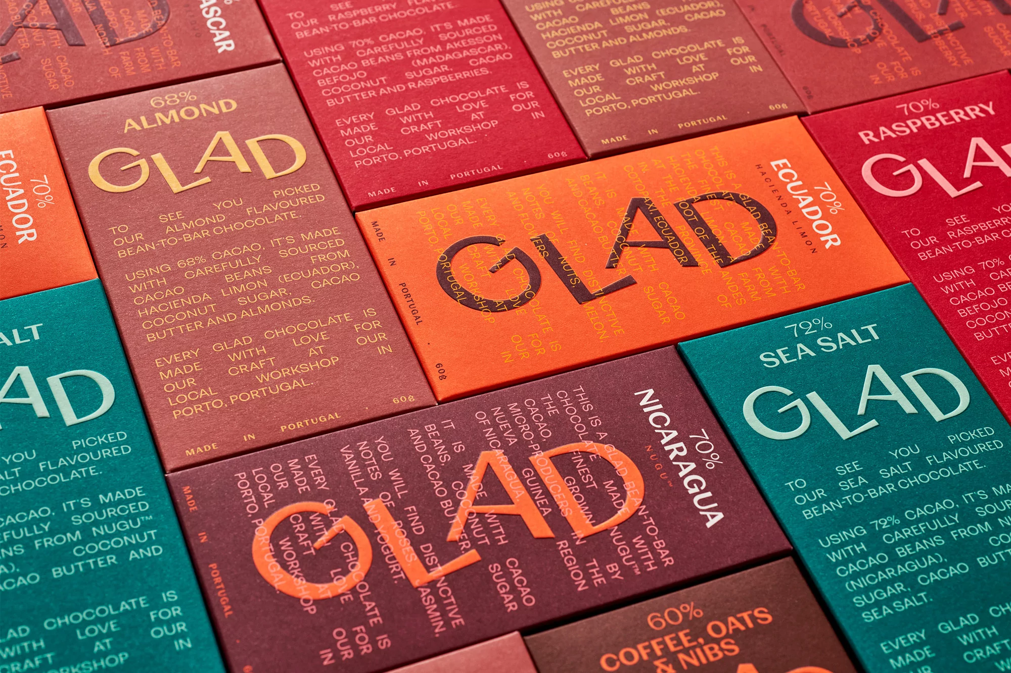 Close-up flat lay of colourful textured chocolate packaging wrappers featuring embossed GLAD branding and typography.