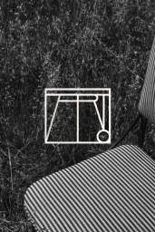 Black and white image of a striped chair outdoors featuring a geometric brand logo overlay
