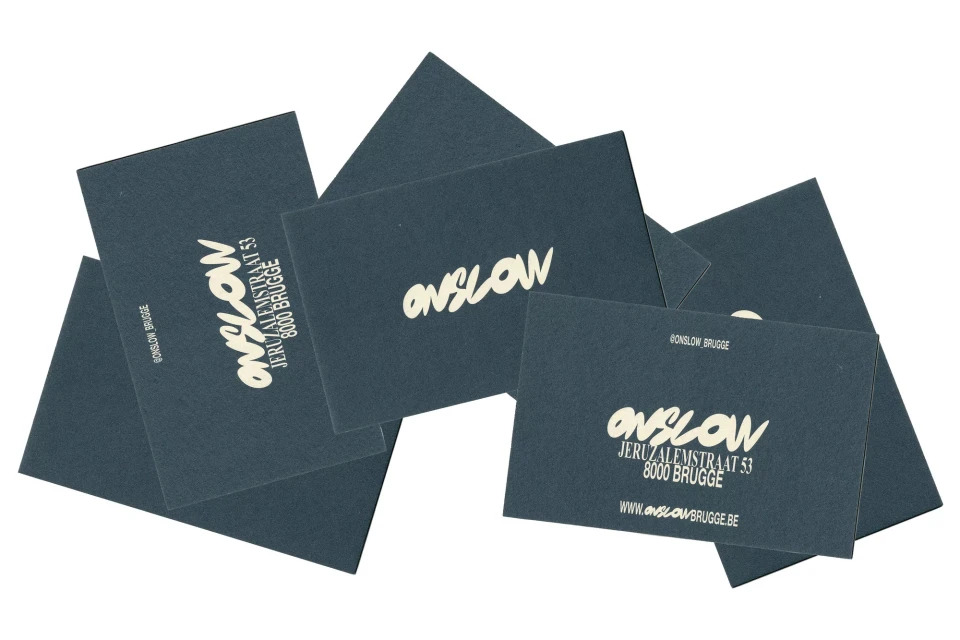 Stacked dark blue business cards with white lettering that reads 'ONSLOW JERUZALEMSTRAAT 53 8000 BRUGGE WWW.ONSLOWBRUGGE.BE'.