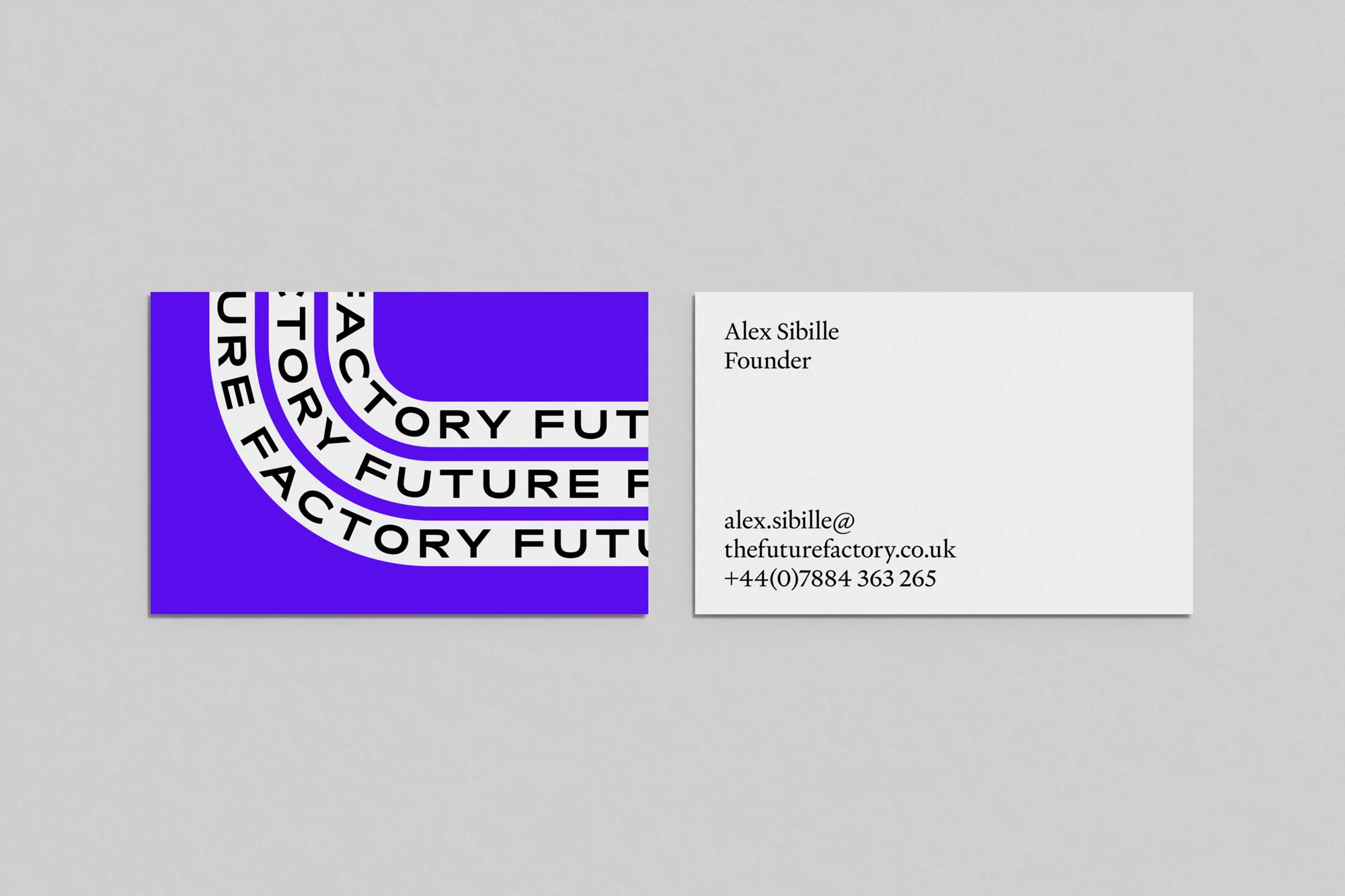 Two business cards showing front with purple curved typography and back with black text on white against grey background.