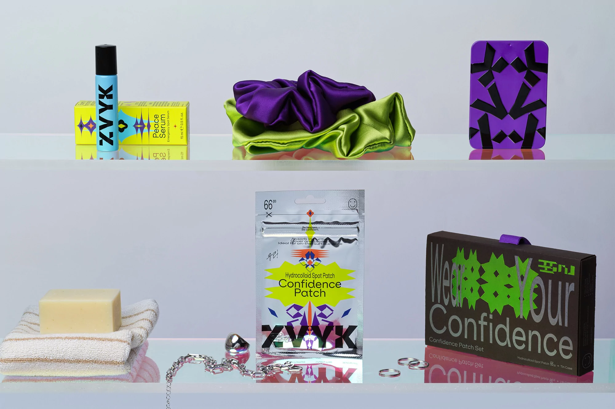 Cosmetic products, including spot patches and serums, are arranged on a shelf against a light gray background in a studio setting.