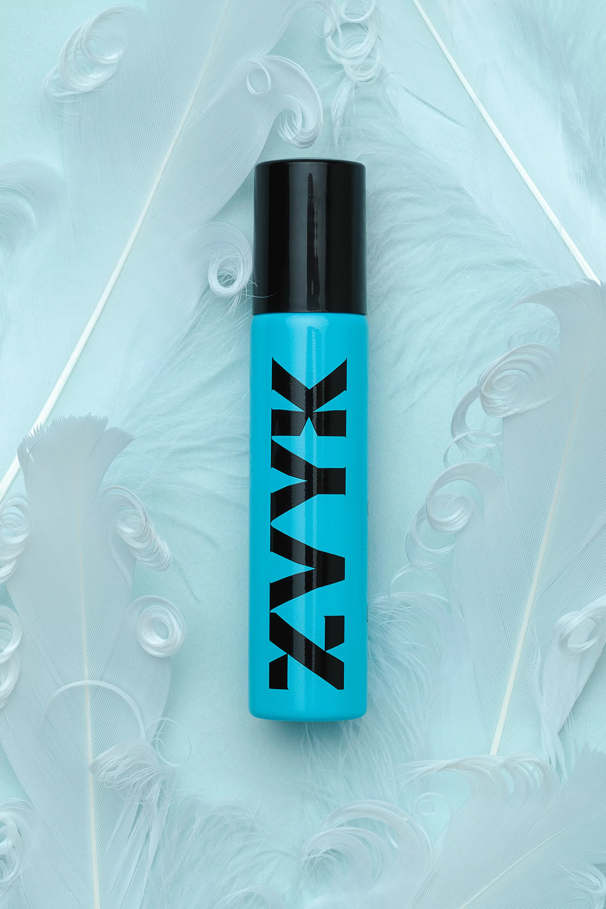 Light blue bottle with black cap and 'ZYAZ' logo on a bed of white feathers, product photography for beauty, fashion, or cosmetic brand.