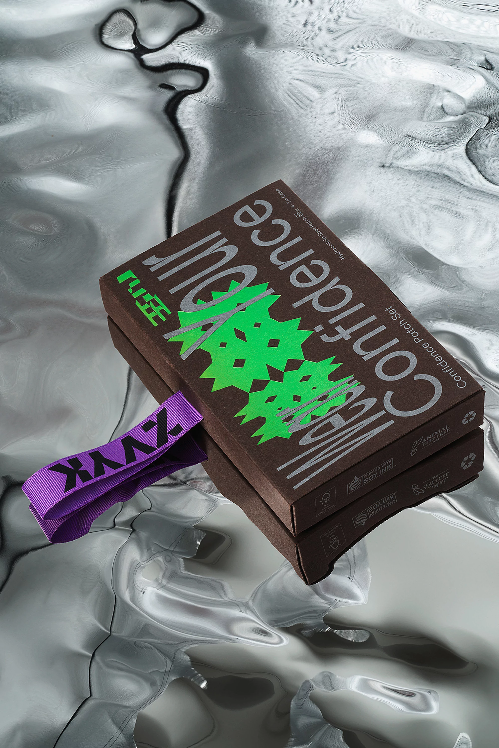 Product photography featuring a confidence patch set box, showcasing its packaging and design on a reflective silver background.