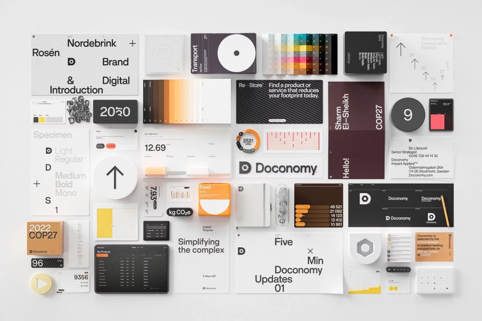 Overhead shot of Doconomy branding materials including cards, screens, and color swatches arranged on a white surface.