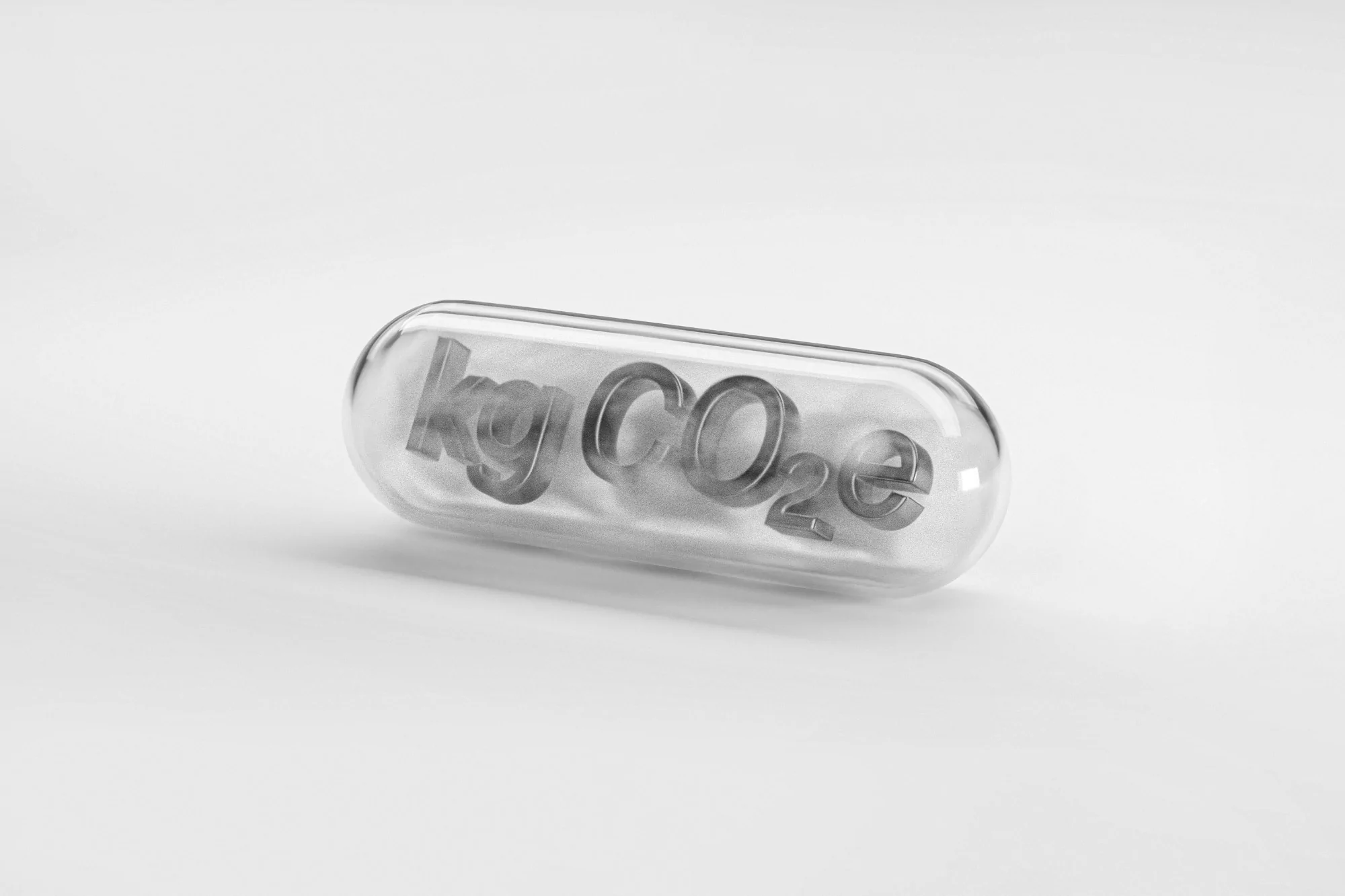 Pill capsule with 'kg CO2e' inside, representing carbon footprint reduction, sitting on a white surface. Clean, studio shot.