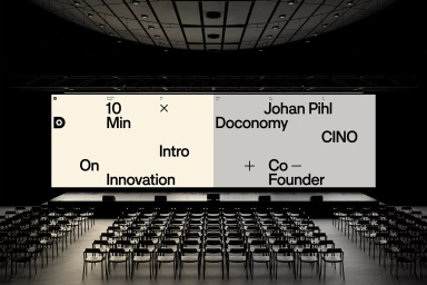 Large wide screen displaying typography in a dark empty auditorium filled with empty rows of chairs.