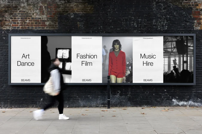 Advertisment billboard on city street featuring imagery for art, fashion, and music services by BEAMS, with a blurred pedestrian.