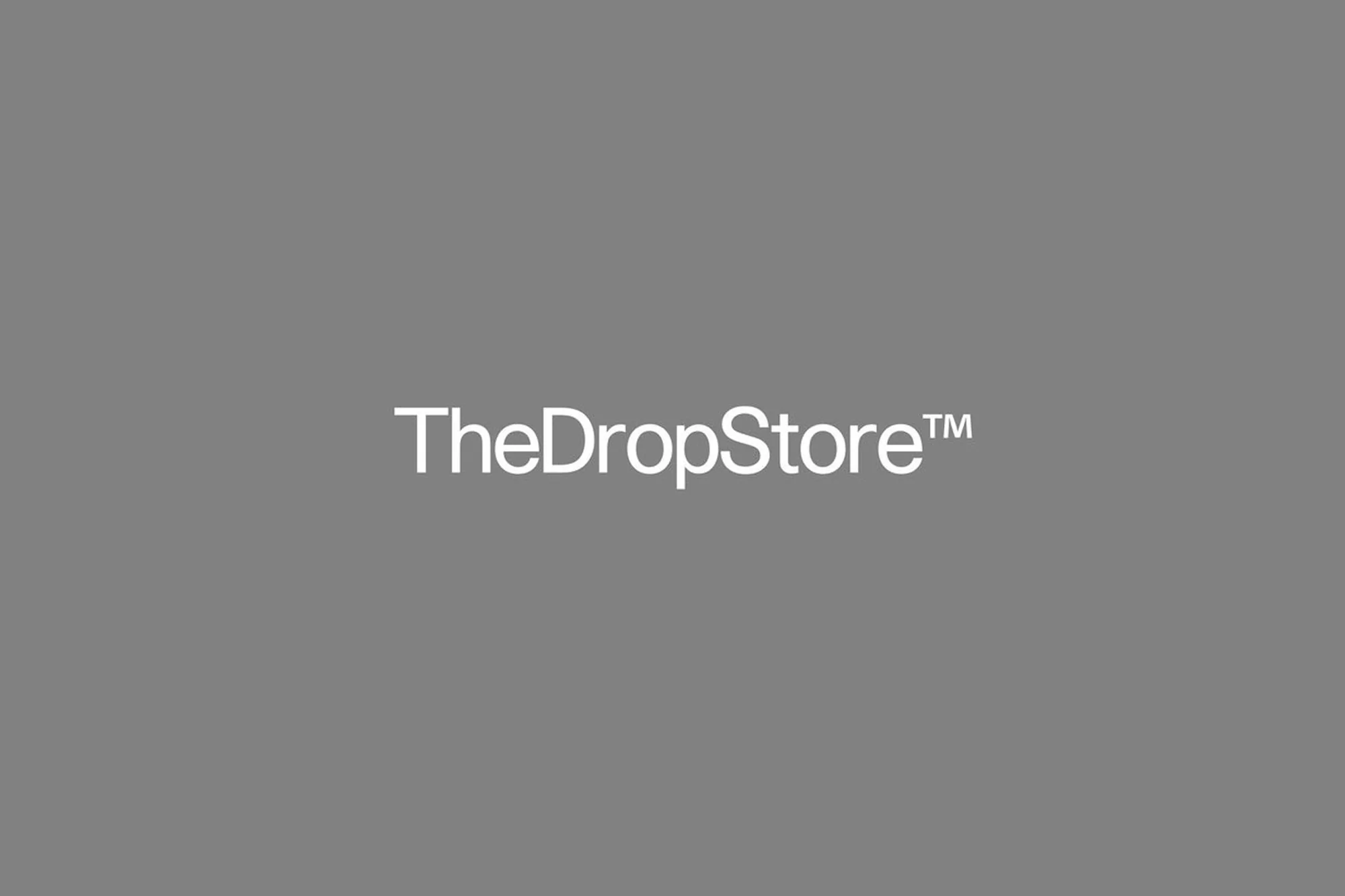 TheDropStore™ logo on a gray background. The text is white, simple, and sans-serif. The background is a solid, neutral gray color.