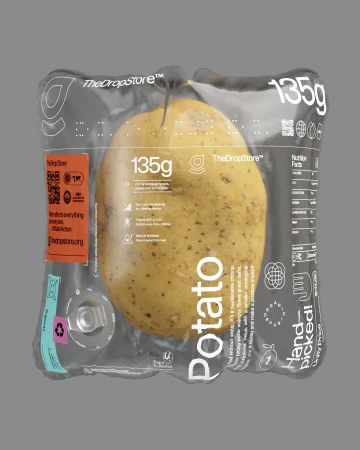 Single potato in clear packaging with black branding and nutrition information on a light grey background in a studio setting.