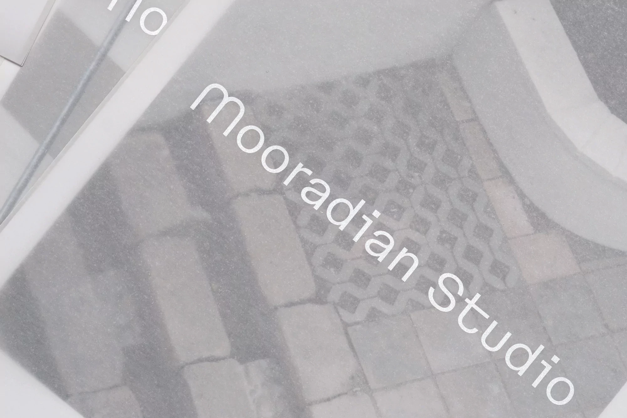 Grey brick and patterned paving stones with white text overlay create an abstract image for architecture or construction searches.