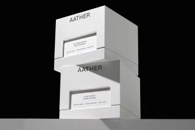 Two stacked white product boxes with minimalist black typography against a solid black background.